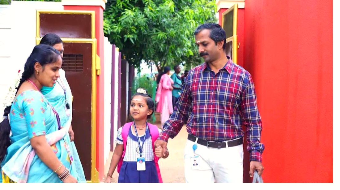 A parent walking a child in through the school gate
